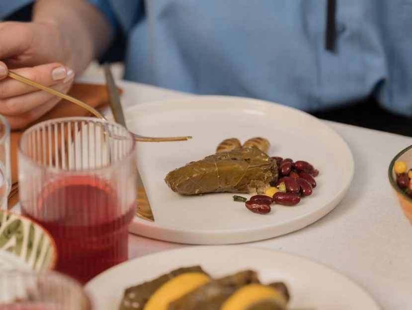 A close-up shot of dolma served with beans and colorful salad, captured during a meal.