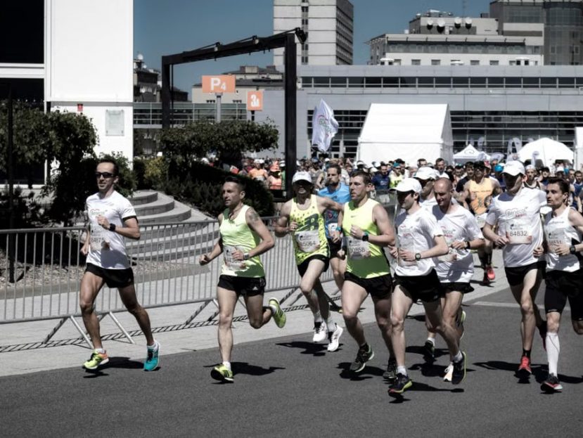 A group of diverse runners competing in an urban marathon on a sunny day.
